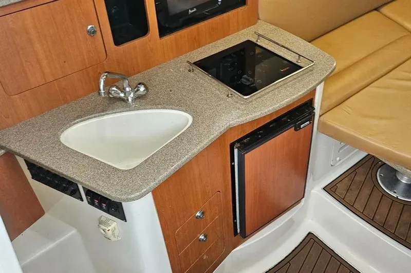 Slide: The Image of Compact kitchen area in a 2007 Sailfish 30-06 Express boat with sink and stove. - 11