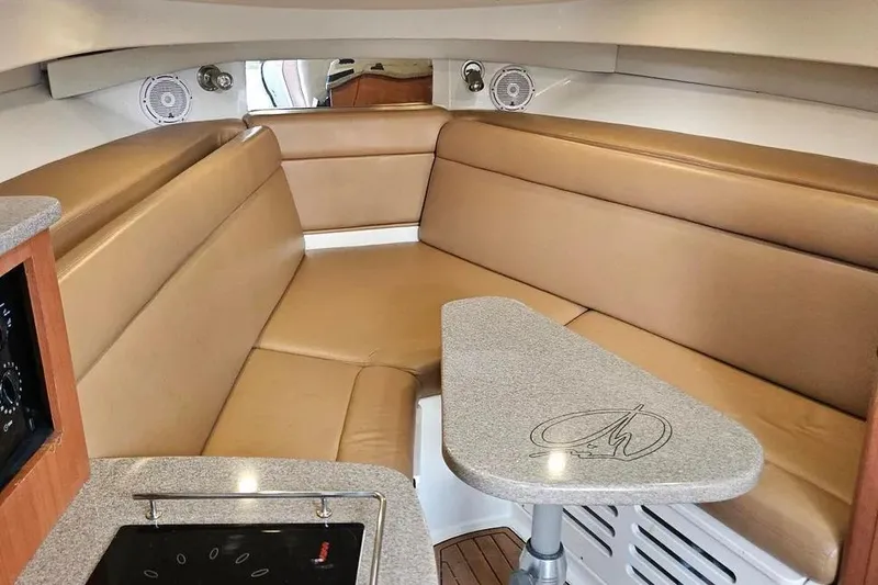 Slide: The Image of Interior of 2007 Sailfish 30-06 Express boat with tan seating and compact table. - 12