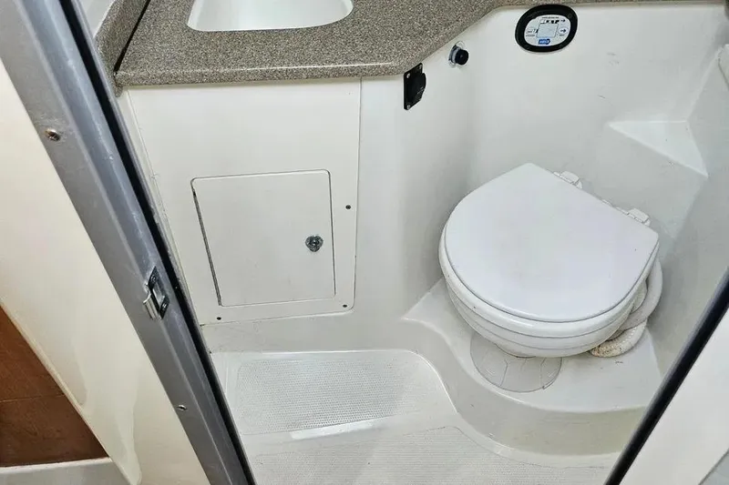 Slide: The Image of Compact bathroom in a 2007 Sailfish 30-06 Express boat, featuring a toilet and sink. - 15