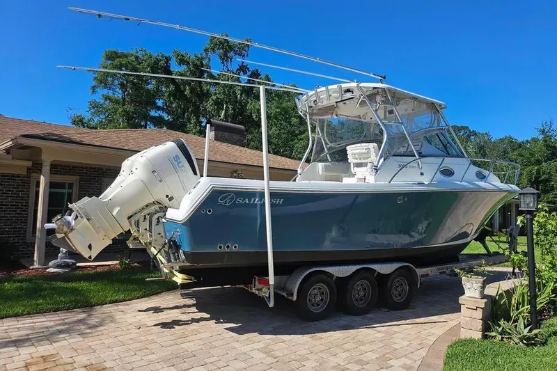 Slide: The Image of 2007 Sailfish 30-06 Express boat on trailer, parked in driveway, clear blue sky. - 2