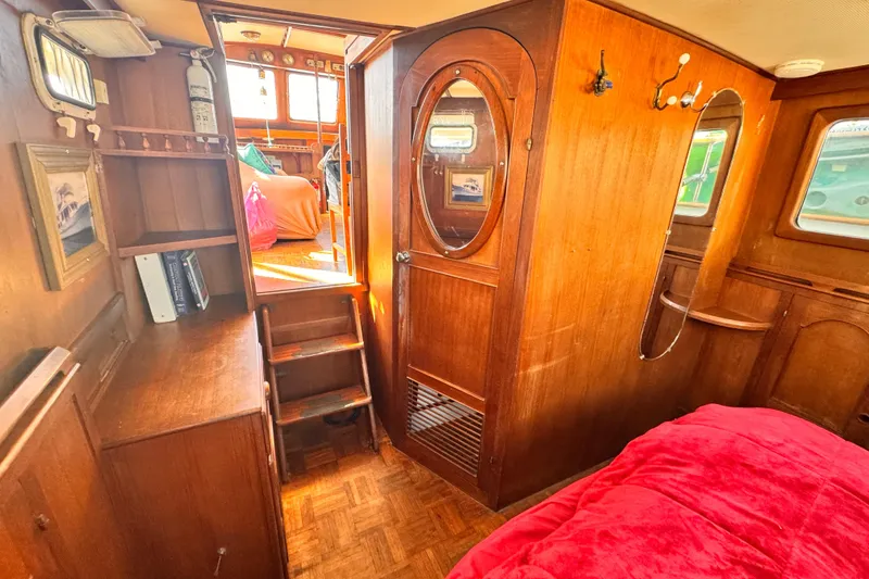 Slide: The Image of 1980 Hershine Trawler interior with wooden cabinetry, stairs, and cozy furnishings. - 11