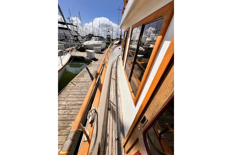 Slide: The Image of 1980 Hershine Trawler docked at marina, surrounded by sailboats under clear blue sky. - 14