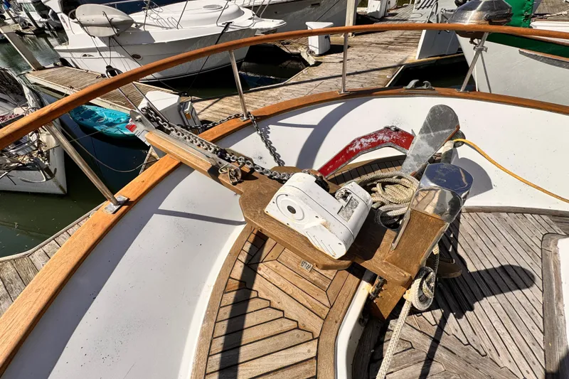 Slide: The Image of 1980 Hershine Trawler docked, showcasing wooden deck and nautical equipment under clear skies. - 16