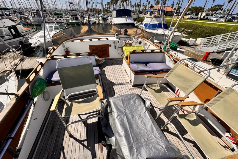 Slide: The Image of 1980 Hershine Trawler docked in marina, clear blue sky, palm trees in background. - 19