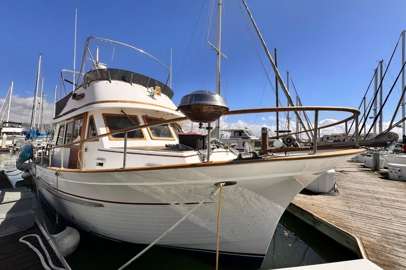 Slide: The Image of 1980 Hershine Trawler docked at marina under clear blue sky. - 2