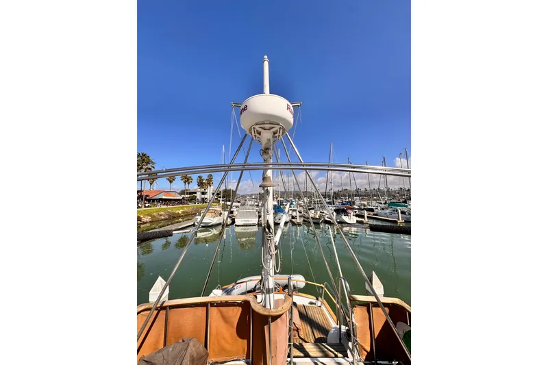 Slide: The Image of 1980 Hershine Trawler docked in marina, clear blue sky, palm trees in background. - 20