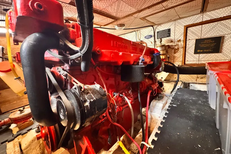 Slide: The Image of Red engine inside a 1980 Hershine Trawler boat, detailed view of mechanical components. - 23