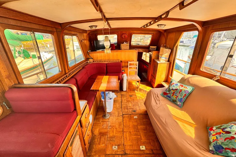 Slide: The Image of 1980 Hershine Trawler interior with cozy seating, wooden accents, and colorful cushions. - 4