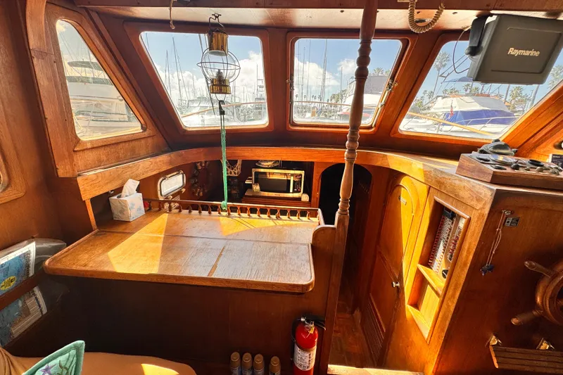 Slide: The Image of 1980 Hershine Trawler interior with wooden helm, windows, and nautical decor. - 6