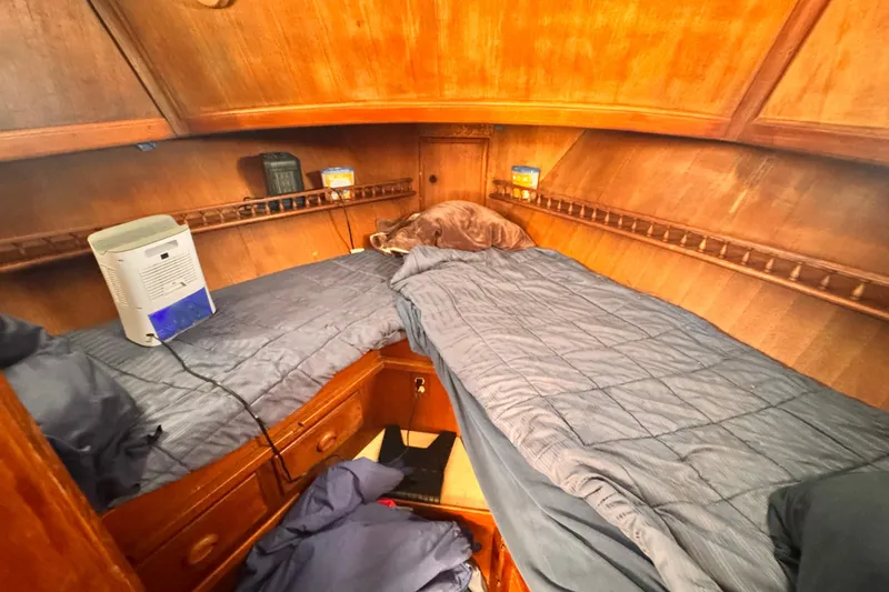 Slide: The Image of Cozy cabin interior of a 1980 Hershine Trawler with twin beds and wooden paneling. - 9