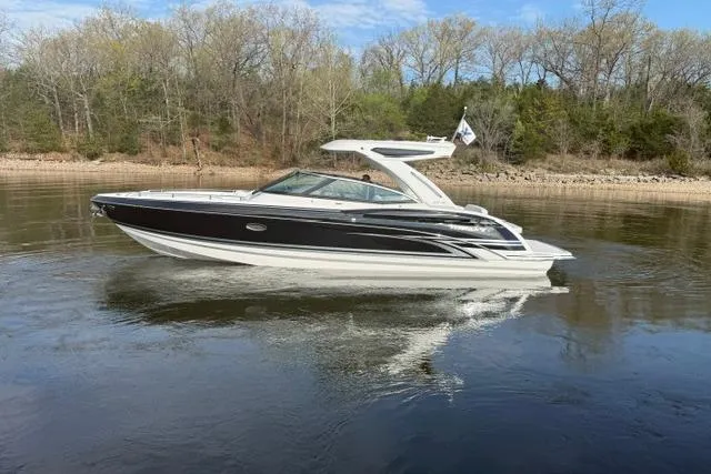Slide: The Image of 2026 Formula 330 Crossover Bowrider I/O cruising on a calm lake with forested shoreline. - 15