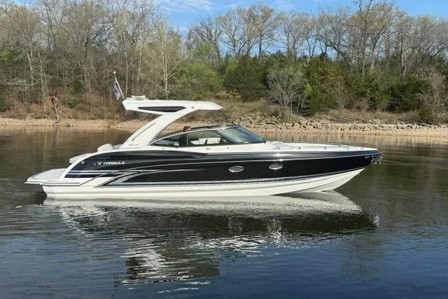 Slide: The Image of 2026 Formula 330 Crossover Bowrider I/O on calm water, surrounded by trees. - 22