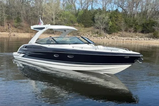 Slide: The Image of 2026 Formula 330 Crossover Bowrider I/O on calm lake with wooded shoreline. - 24