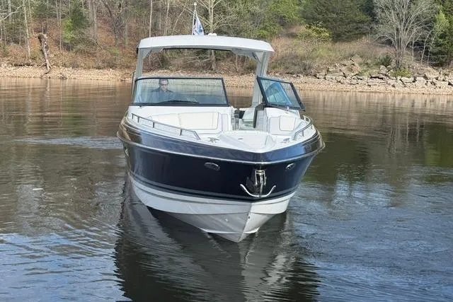 Slide: The Image of 2026 Formula 330 Crossover Bowrider I/O on calm lake waters, surrounded by trees. - 27