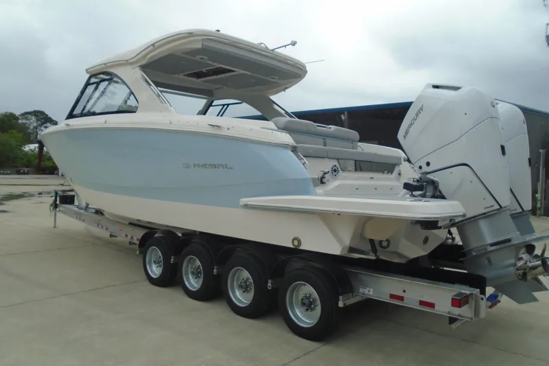 The Image of 2026 Regal LX36 boat on trailer with dual Mercury outboard engines. - 0