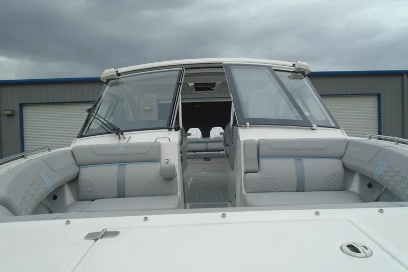 Slide: The Image of 2026 Regal LX36 boat with sleek design and spacious seating under cloudy skies. - 10