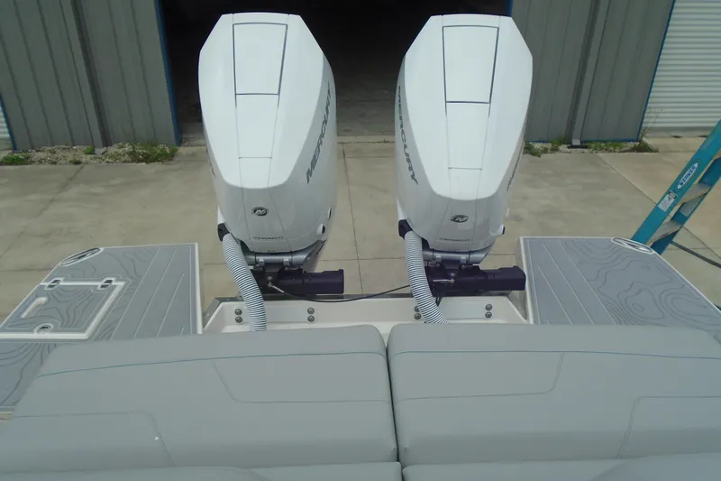 Slide: The Image of Twin Mercury outboard engines on a 2026 Regal LX36 boat, docked in a marina. - 24