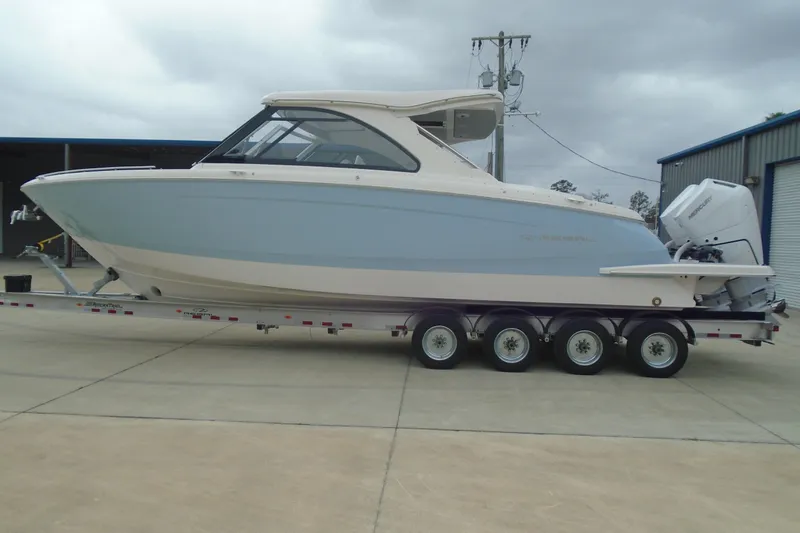 Slide: The Image of 2026 Regal LX36 boat on trailer, parked outdoors, showcasing sleek design and modern features. - 29