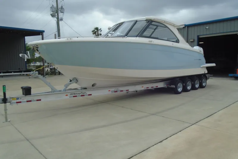Slide: The Image of 2026 Regal LX36 boat on trailer in a marina setting. - 30