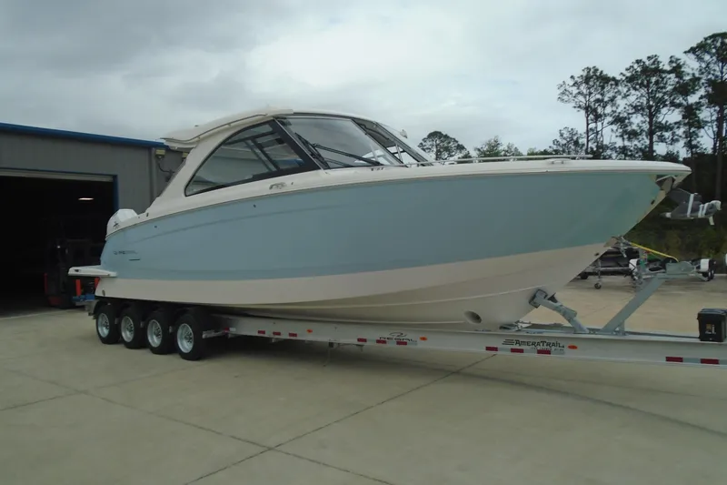 Slide: The Image of 2026 Regal LX36 boat on trailer, parked outdoors near a building. - 31