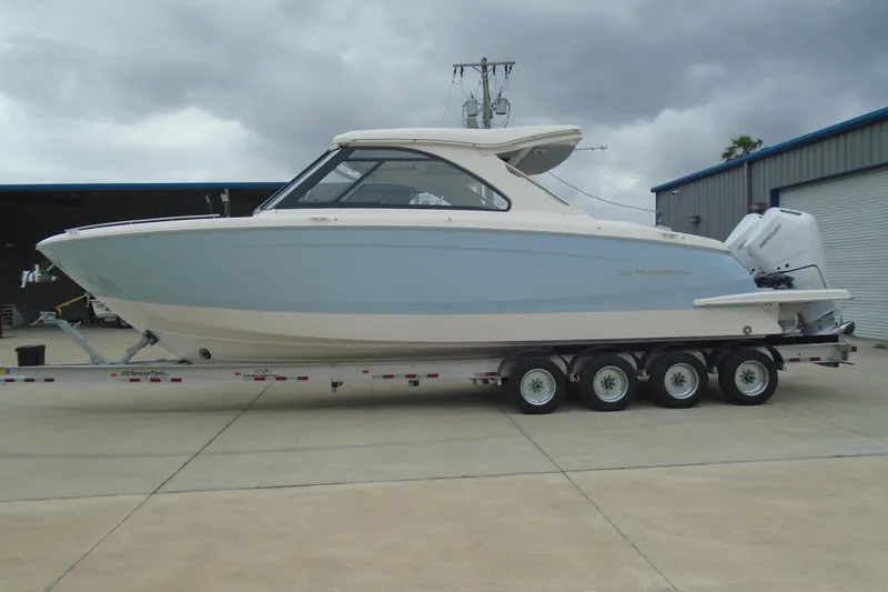 Slide: The Image of 2026 Regal LX36 boat on trailer, parked outdoors under cloudy sky. - 6