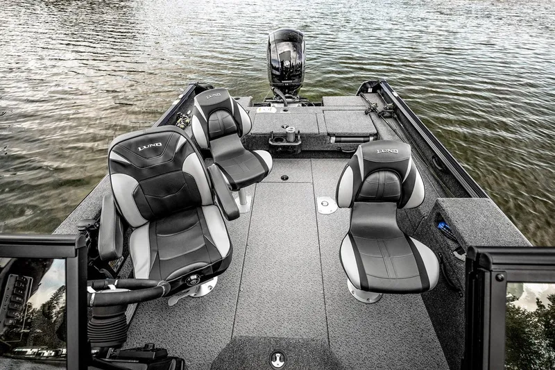 Slide: The Image of 2026 Lund 1875 Impact XS Sport boat with cover, parked at Crestliner Boats dealership. - 3