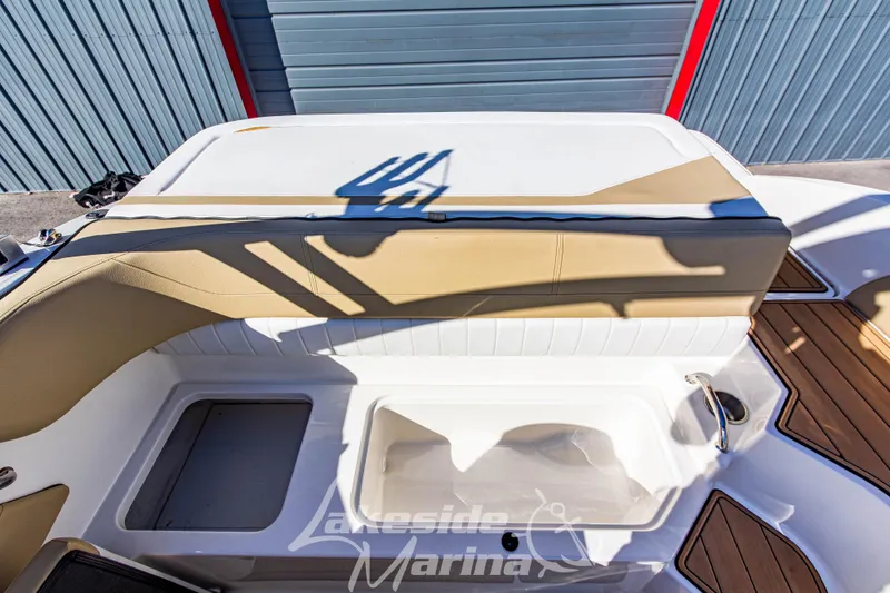 Slide: The Image of 2016 Sea Ray SPX 190 boat interior with tan and white seating, docked at marina. - 14