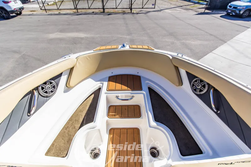 Slide: The Image of 2016 Sea Ray SPX 190 boat interior with teak flooring and beige seating. - 25