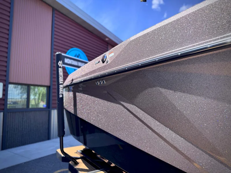 Slide: The Image of 2026 Nautique G25 boat with sparkling hull in front of a building. - 17