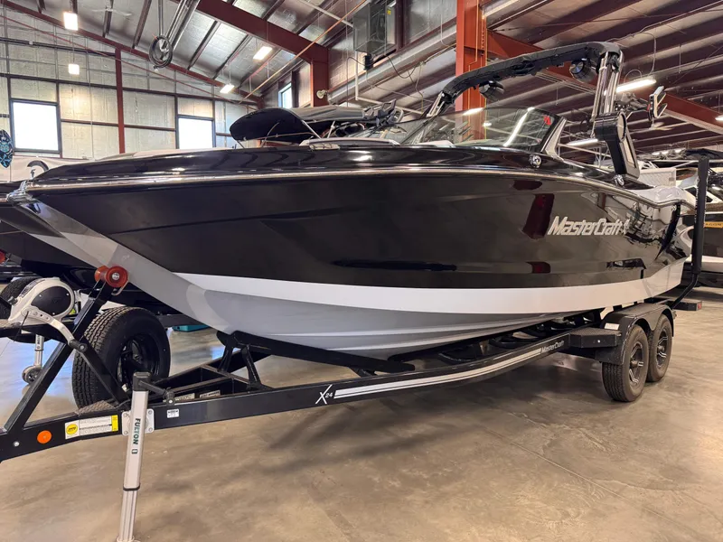 The Image of 2023 MasterCraft X24 boat in a warehouse on a trailer. - 1