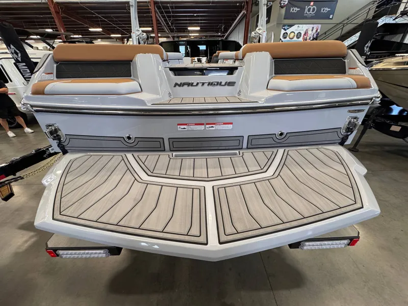 Slide: The Image of Rear view of 2026 Nautique Super Air Nautique GS22 boat in showroom. - 4