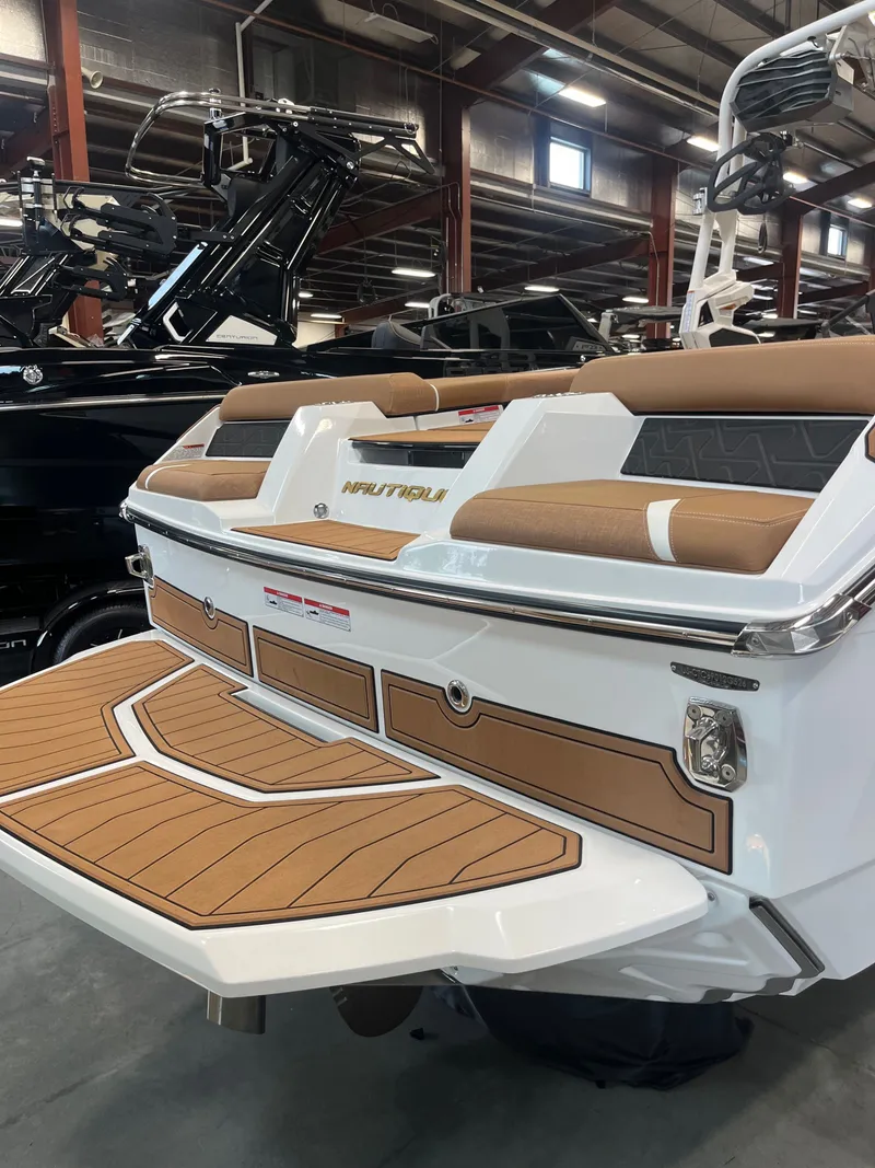 Slide: The Image of Rear view of 2026 Nautique GS24 boat in showroom. - 6
