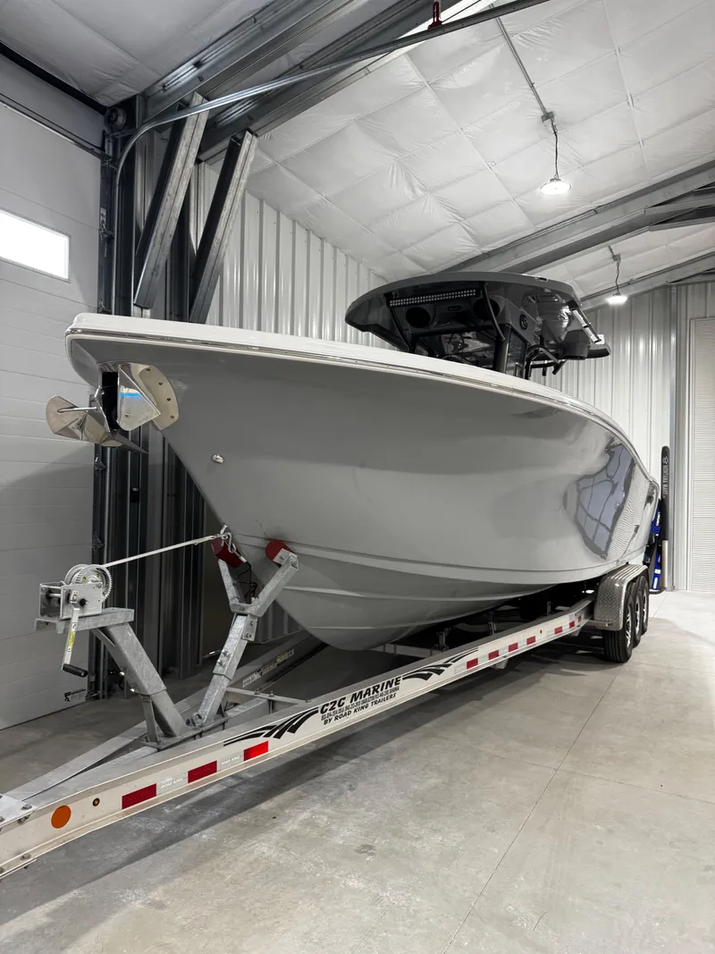 The Image of 2025 Sea Pro 292 DLX boat on trailer in storage facility. - 1