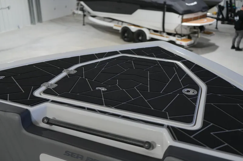 Slide: The Image of Sea Pro 292 DLX 2025 boat with modern deck design in a showroom. - 11
