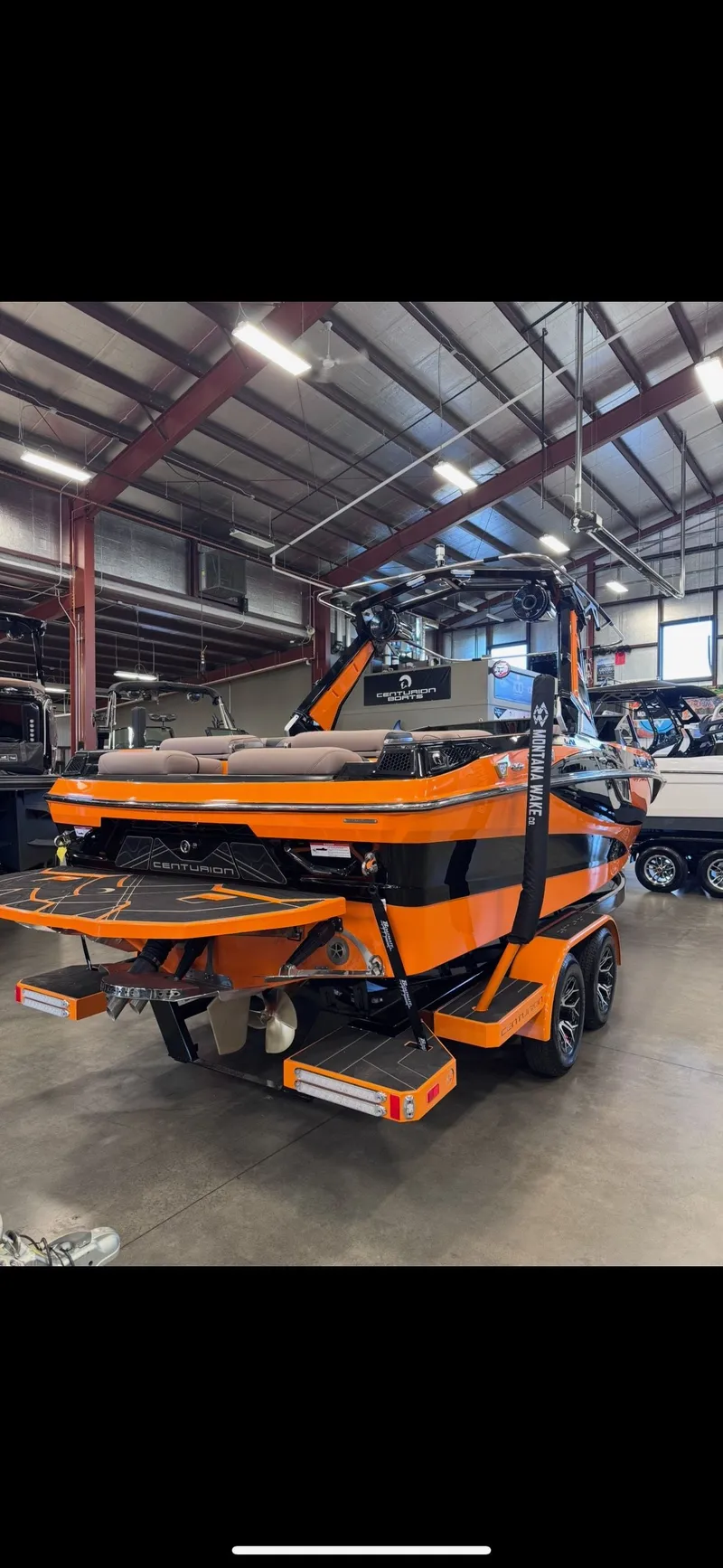 Slide: The Image of 2026 Centurion Fe23 boat in vibrant orange inside a warehouse. - 3