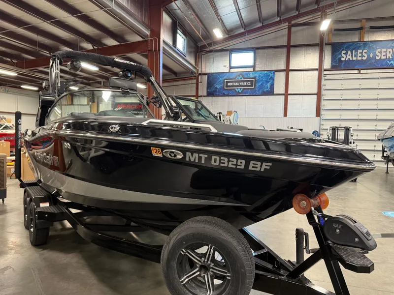 Slide: The Image of Black 2022 MasterCraft XT21 boat in a warehouse setting. - 5