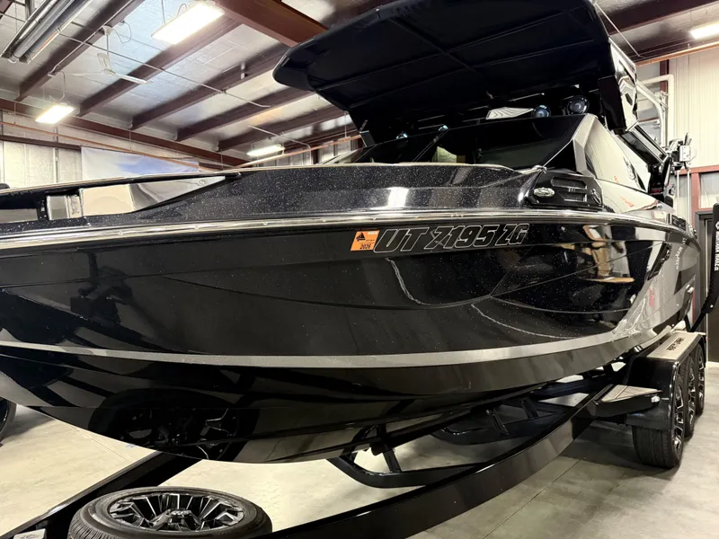 Slide: The Image of Black 2025 Centurion Ri245 boat in a warehouse setting. - 4