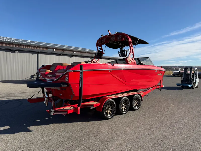 Slide: The Image of Red 2021 Nautique G25 boat on trailer outdoors. - 3