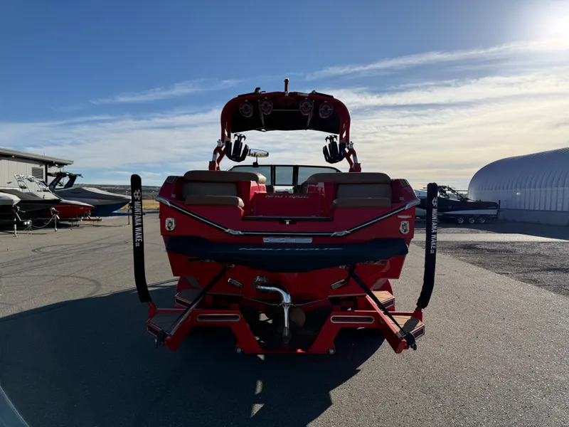 Slide: The Image of Red 2021 Nautique G25 boat parked outdoors. - 4