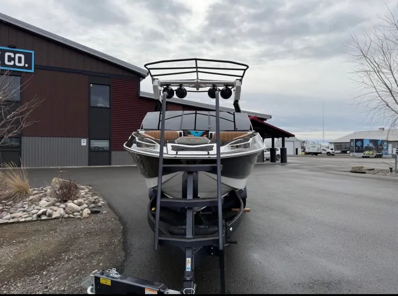 Slide: The Image of 2026 Centurion Ri 265 boat on trailer in front of building. - 7