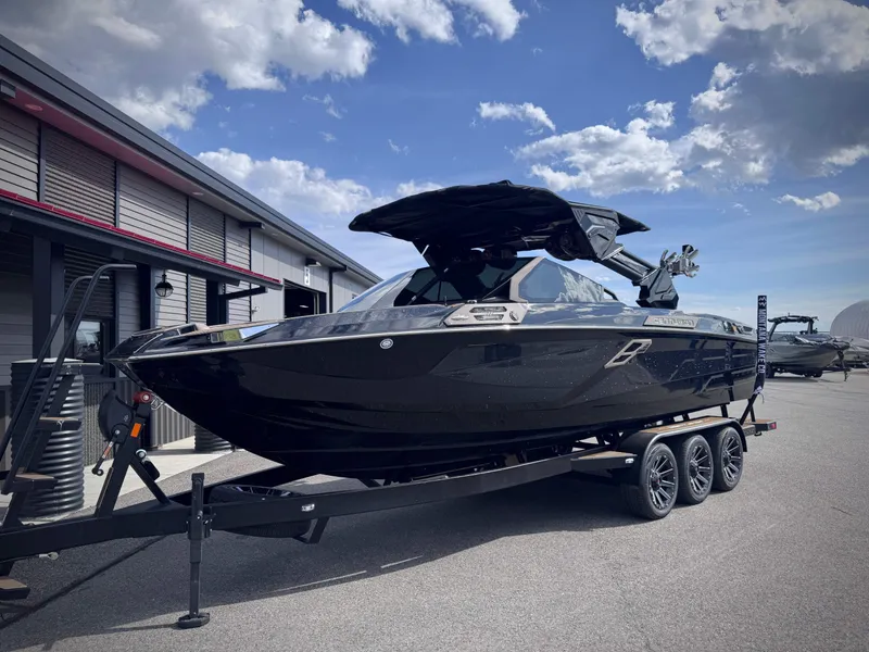 Slide: The Image of 2026 Centurion Ri245 boat on trailer under blue sky. - 27