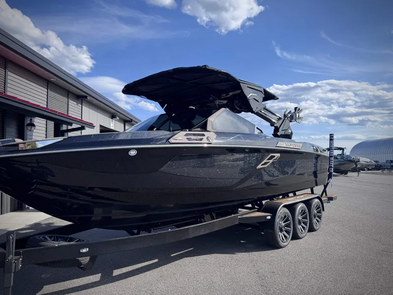 Slide: The Image of 2026 Centurion Ri245 boat on trailer under sunny skies. - 31