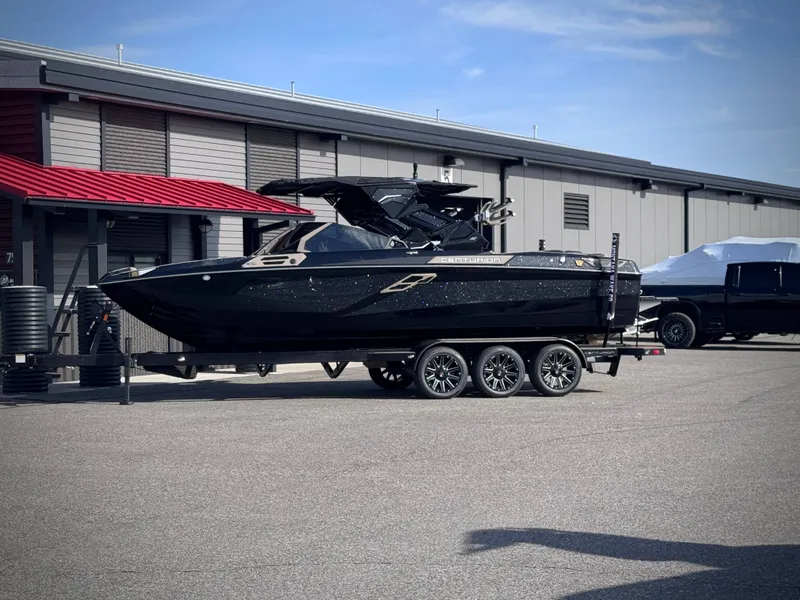 Slide: The Image of 2026 Centurion Ri245 boat on trailer in front of building. - 32