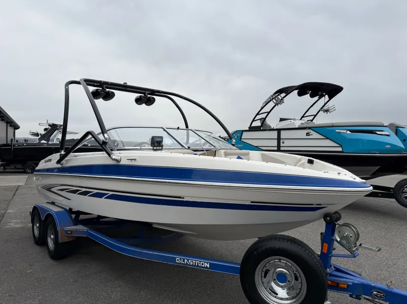 The Image of 2008 Glastron GT 205 boat on trailer, blue and white design. - 1