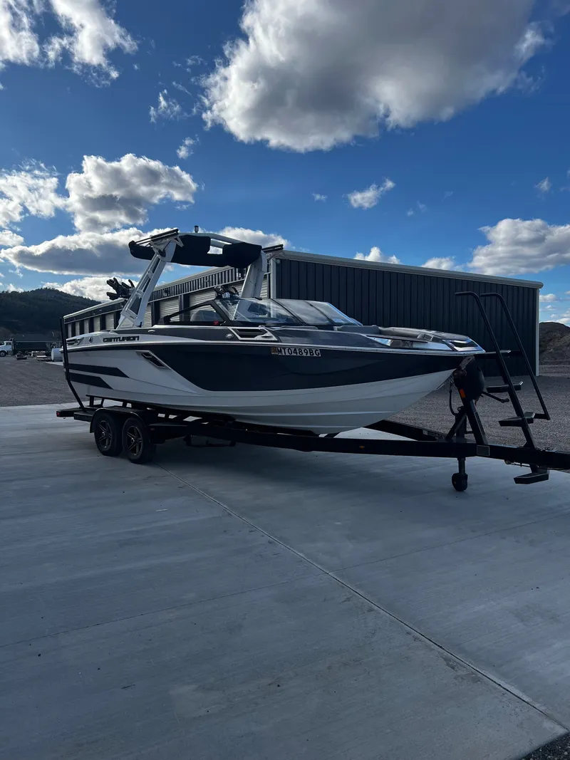 Slide: The Image of 2023 Centurion Ri230 boat on trailer under blue sky. - 5