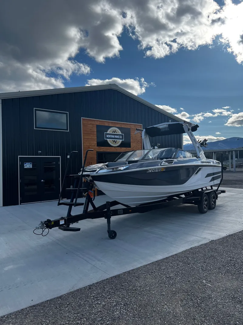 Slide: The Image of 2023 Centurion Ri230 boat in front of a building under cloudy sky. - 6