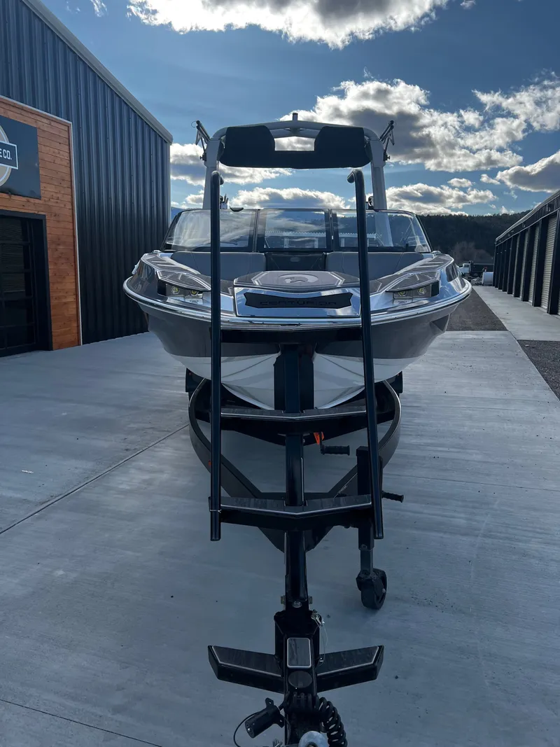 Slide: The Image of 2023 Centurion Ri230 boat on trailer outside warehouse. - 7