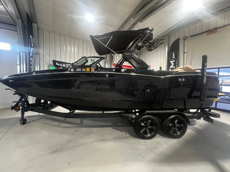 The Image of 2024 MasterCraft X STAR S boat in black finish inside a showroom. - 1