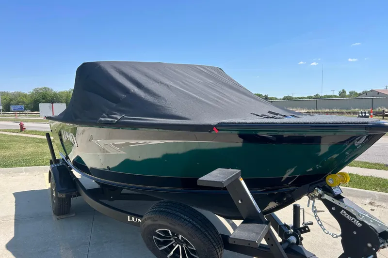 Slide: The Image of 2026 Lund 1775 Impact XS Sport boat with cover on trailer, parked outdoors. - 11
