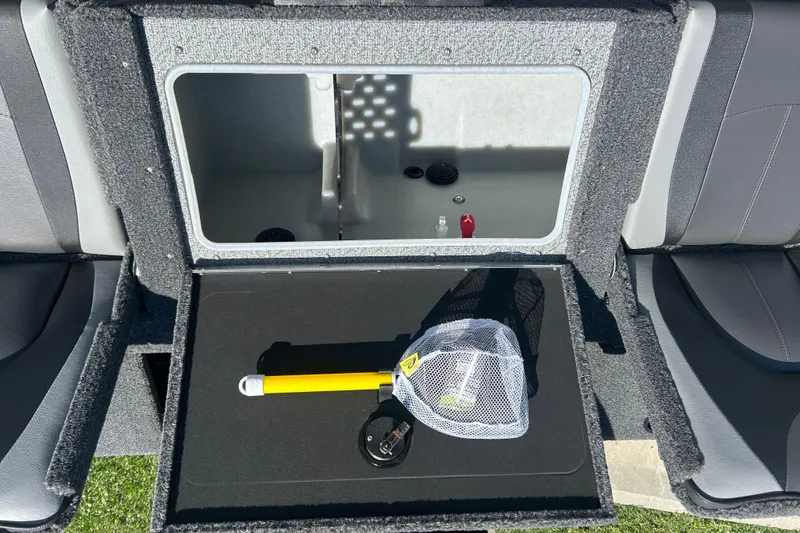 Slide: The Image of 2026 Lund 1775 Impact XS Sport boat storage compartment with fishing net and accessories. - 14